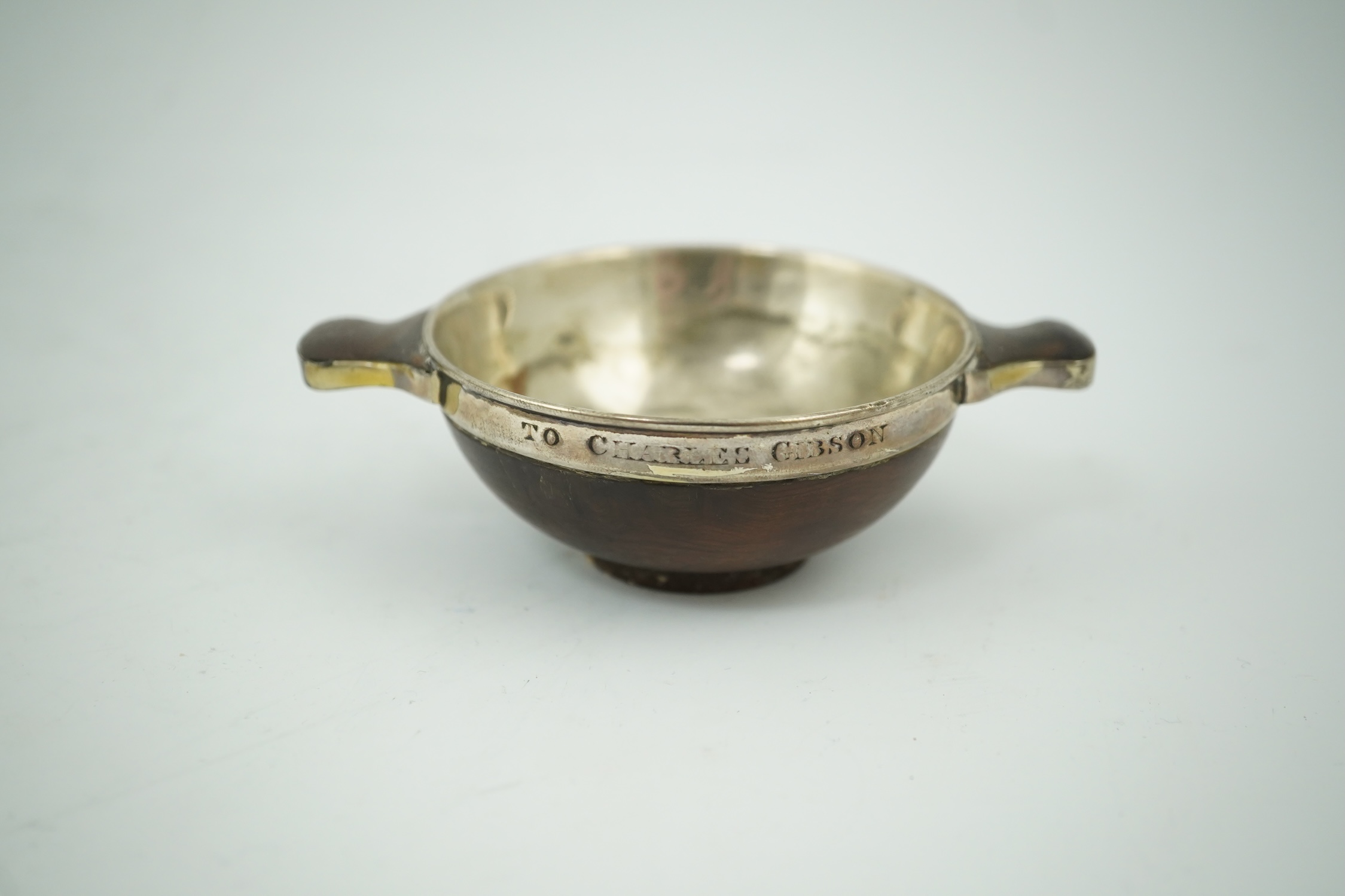 An early 19th century silver mounted yew wood quaich, inscribed 'Scuab As E' to the bowl and 'To Charles Gibson / From A Butter of Faskally' around the rim, dated 1830 beneath one handle, 10.6cm over handles. Condition -